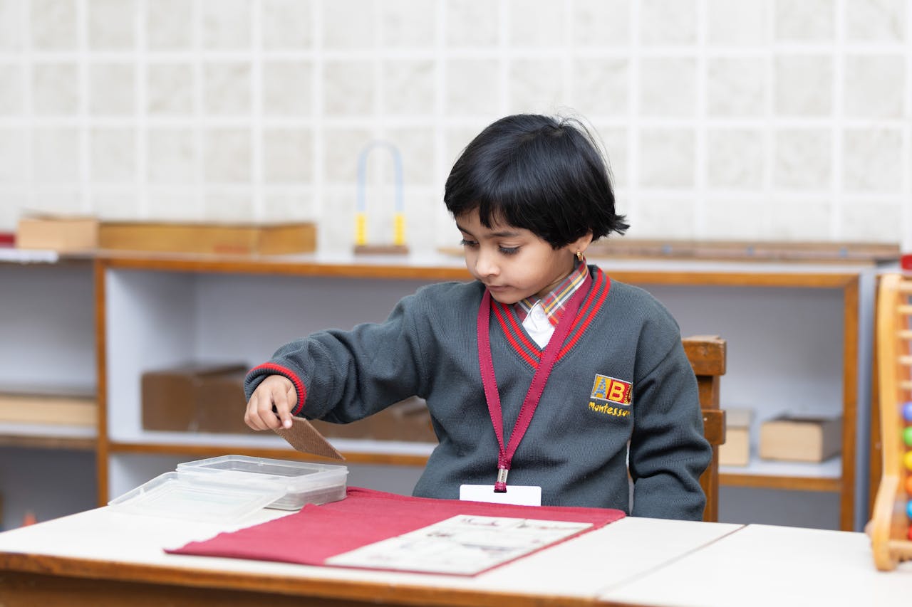 Young child working independently with a Montessori practical life activity in preschool