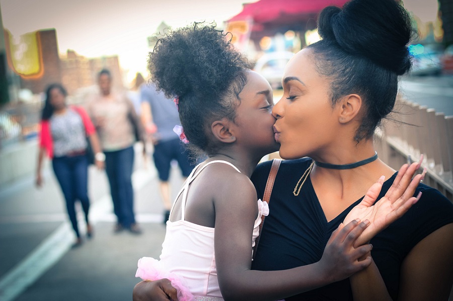 A mother and her young daughter sharing an affectionate moment, modeling warmth and respect
