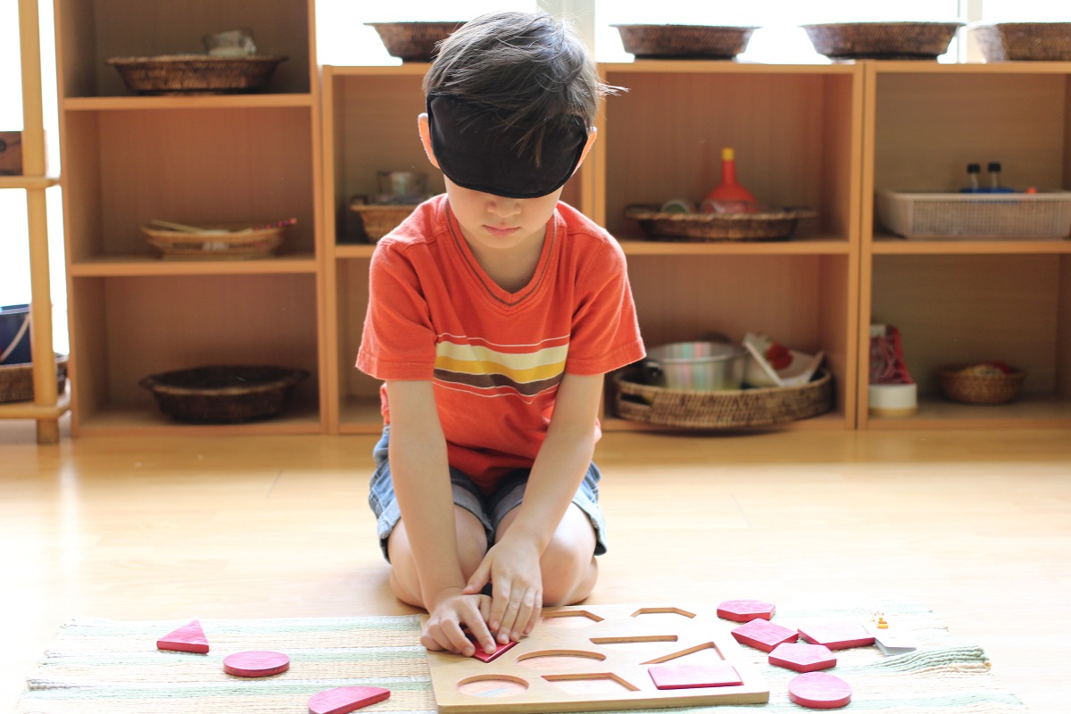 A child working independently with a hands-on Montessori material in a prepared classroom