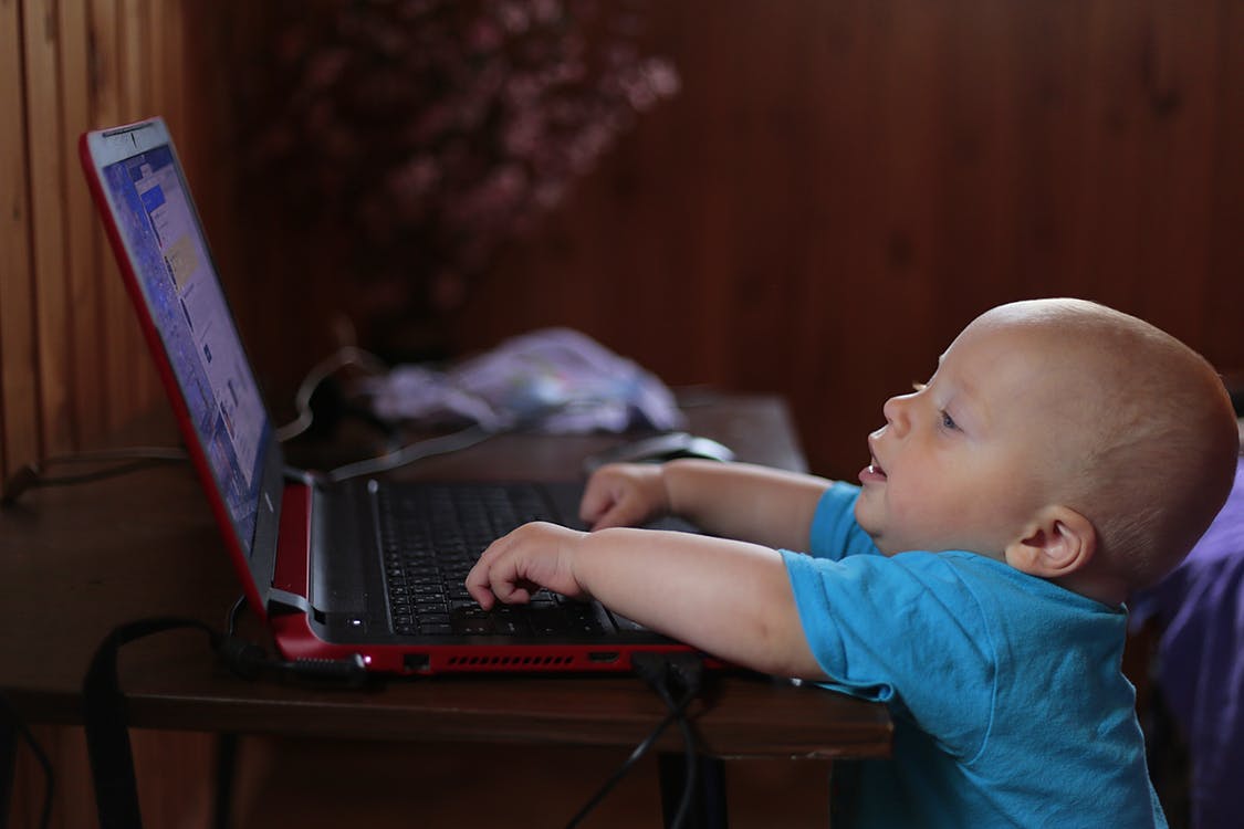 A young child sitting away from a screen, engaged in hands-on play instead