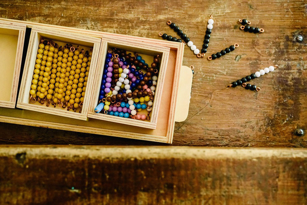 A young child writing in a Montessori classroom environment