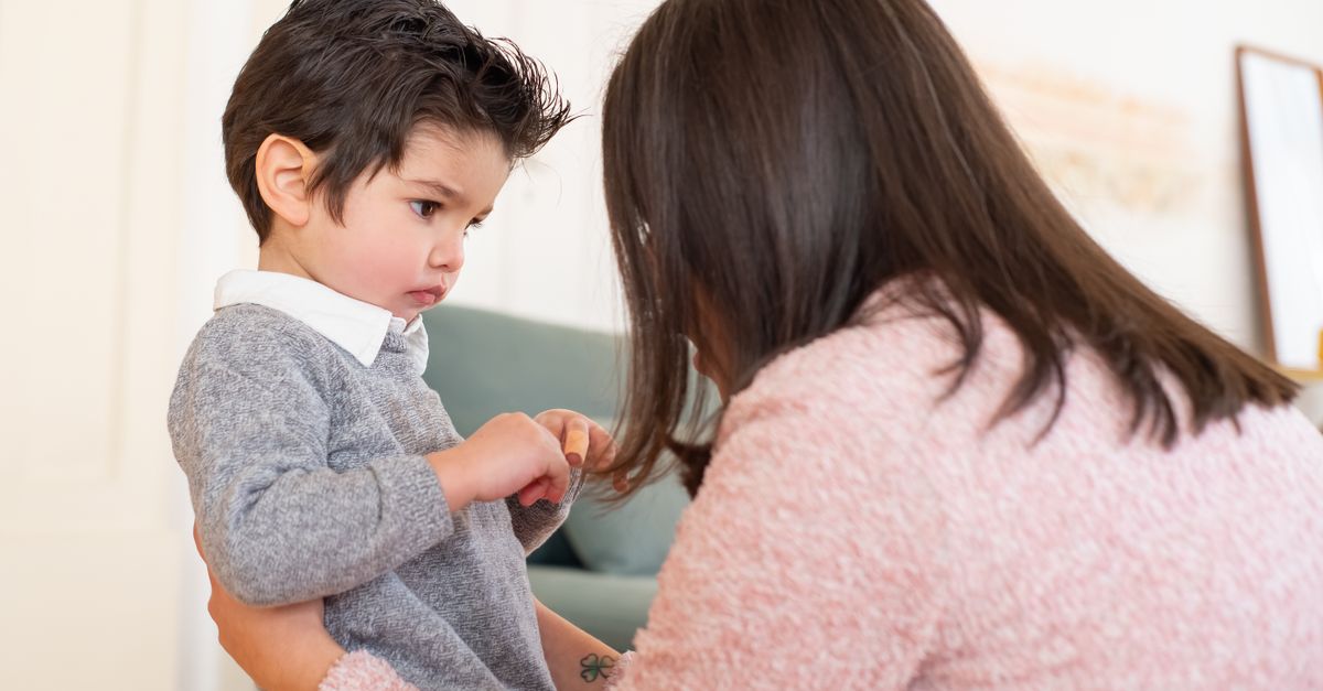 A parent kneeling at eye level to talk calmly with a young child