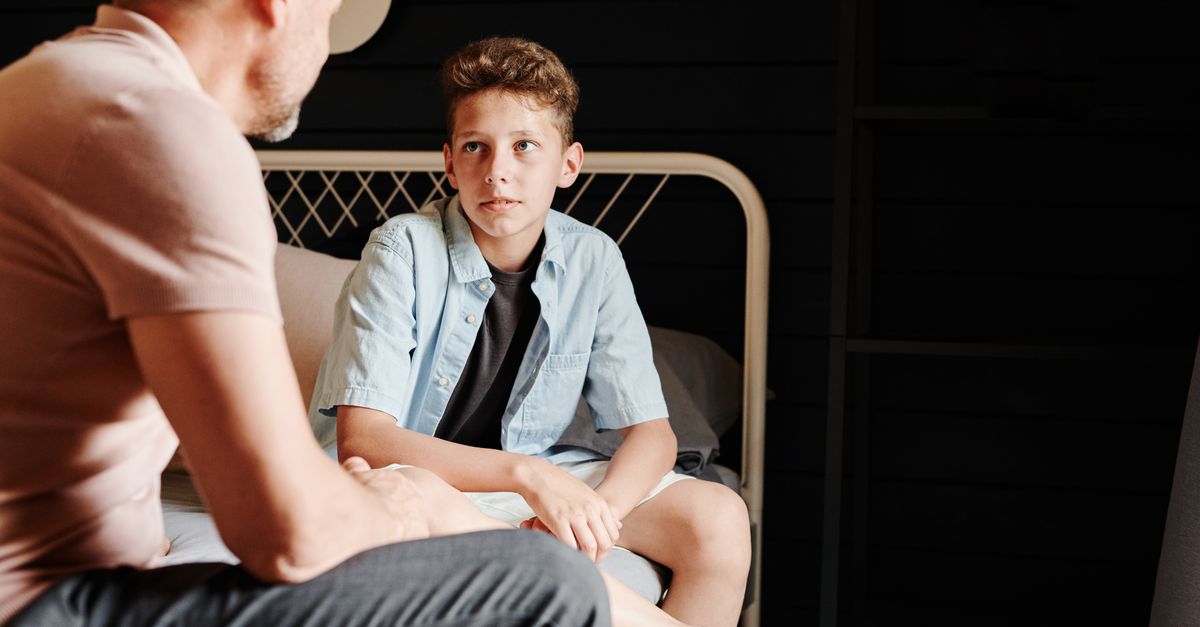 A parent kneeling to talk with a young child at eye level about a personal boundary